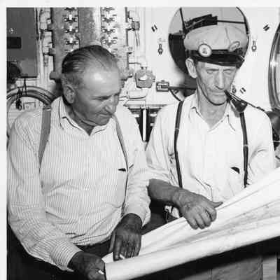 Two men holding map in PC-590