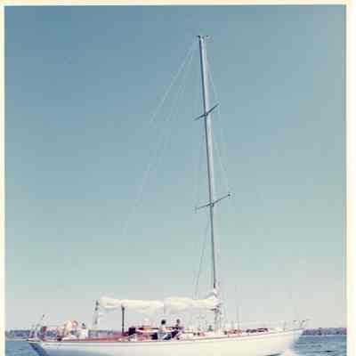 Sailboat underway with three people on boat