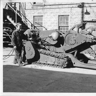 Wally Ives alongside a piece of digging equipment