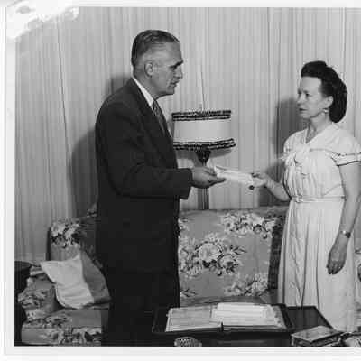 Unidentified man handing check to Alva Smith