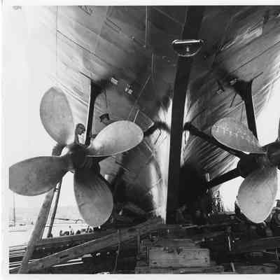 Unidentified vessel showing men working on two propellers