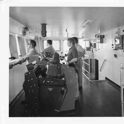 Alcoa Seaprobe pilot house and instrument with four people at steering console