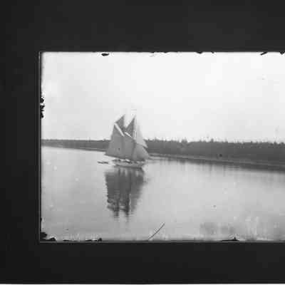 Sailing vessel underway with trees in background
