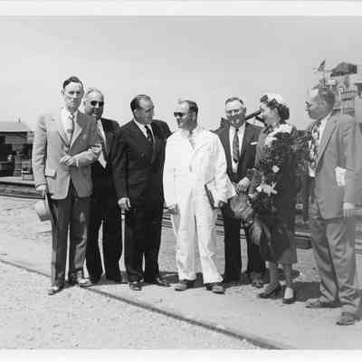 Joesph and Joan McCarthy standing with group of men at launching of LST-1170, May 22, 1954