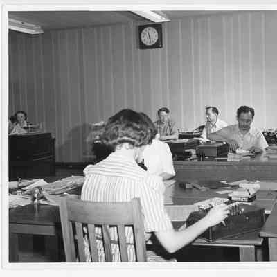 Unidentified men and women at desks