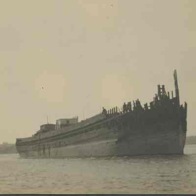 Men standing on floating hull