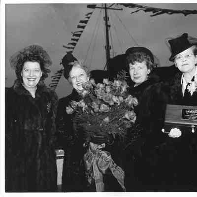 Three women and Mrs. Edward Frick holding roses and sponsor box