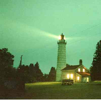 Cana Island Keeper's house at night with lights on in house