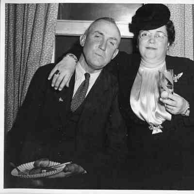 Unidentified man and woman eating and drinking