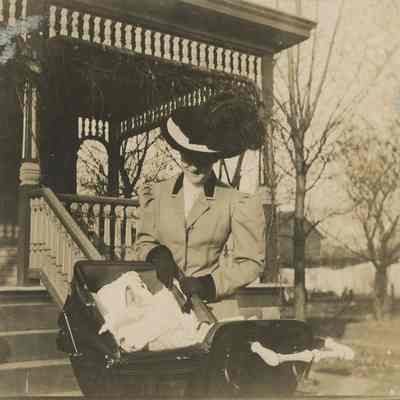 Woman standing next to baby in carriage