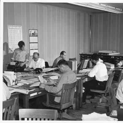 Seated at desks in office at L.D. Smith Shipbuilding Co.