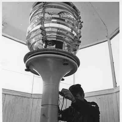 Technician checking electronics for Fresnel lens