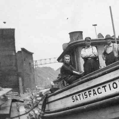 People on deck of Satisfaction docked