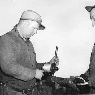 John McAteer and Bill Nelson working at machine