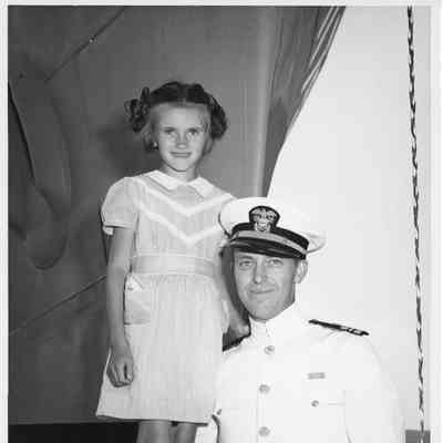 Man in unidentified man in white navy uniform with girl