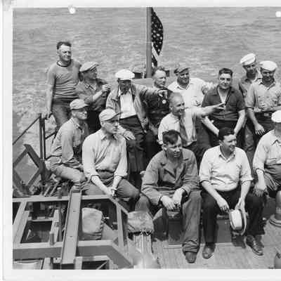 Group of men sitting on stern of vessel underway May 1944