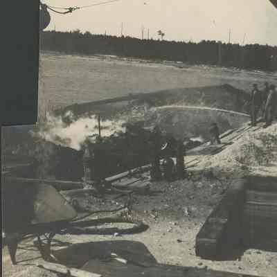 Workers pumping water onto coal