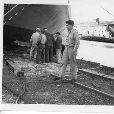 Hull being examined by a group of men at Christy Corp