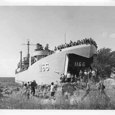People standing on shore in front of LST-1166, September 4, 1953
