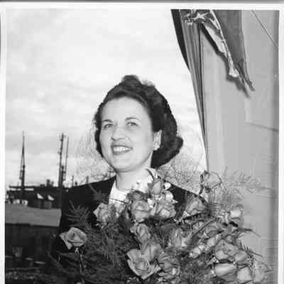 YW-129 ship sponsor holding flowers at ship christening
