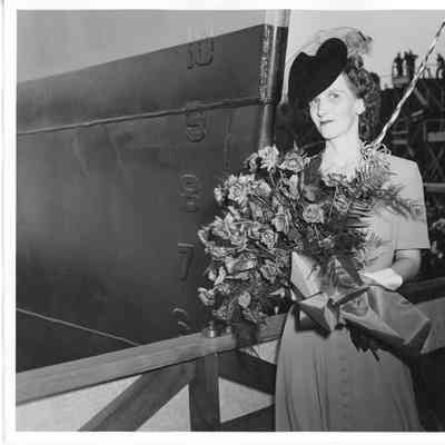 Mrs. Gus Johnson holding roses at christening of PF-64 USS Knoxville