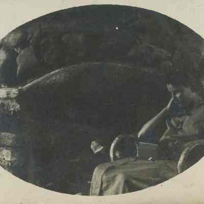 Young woman seated in front of a fireplace