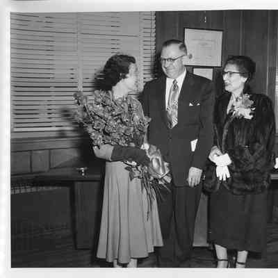 C. Ray Christianson with two women in his office during christening of LST-1168 November 28, 1953