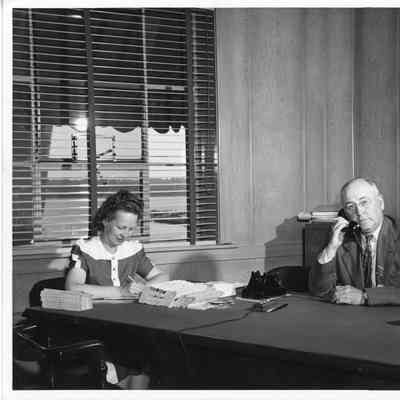 Leathem D. Smith seated at desk with Alva F. Smith