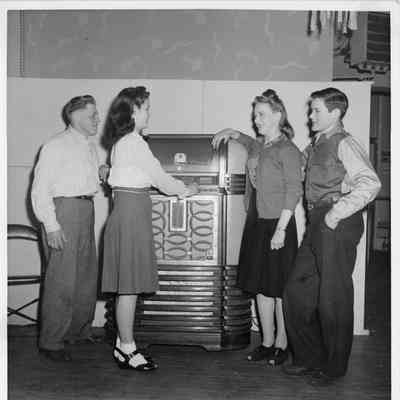 Four children standing next to Juke Box