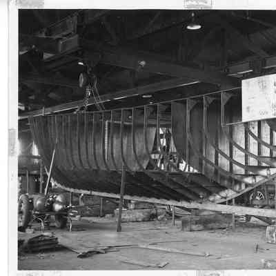 Stern view of metal skeleton of hull on wooden supports
