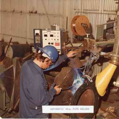 Man in hard hat with Miller Automatic Pipe Welder