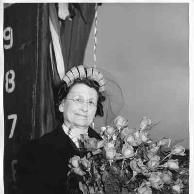 Mrs. Jos. O'Boyle holding roses in from of bow