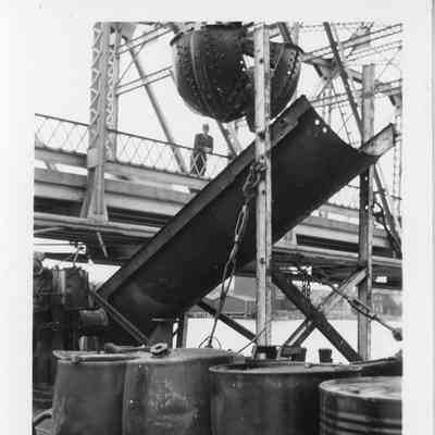 Barrels on barge Transport next to bridge