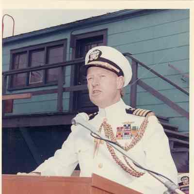 Man at podium speaking at PG-99 USS Beacon launch