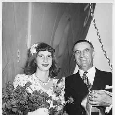 Miss Joan Burgess holding roses at PC-1175 christening