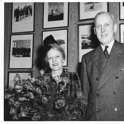 Mrs. Edward Frick holding roses with Mr. Edward Frick