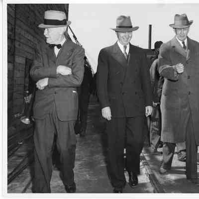 Three unidentified men in dress clothes