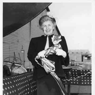 Woman holding christening bottle before ship christening