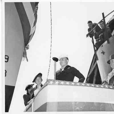 Unidentified navy man at microphone alongside Mrs. Willaim E. Wagener