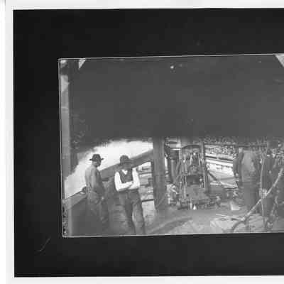 Men standing on deck near machinery