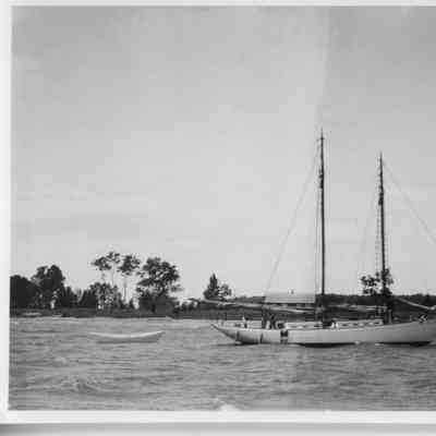 two masted sailboat and dory in water