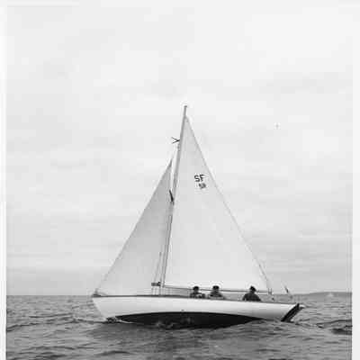 1 masted sailboat with 3 men aboard