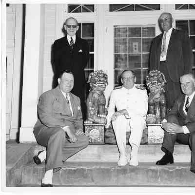 L.D. Smith and four men next to two statues