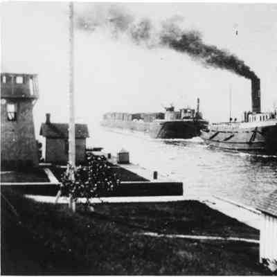 Freighter towing barge into canal