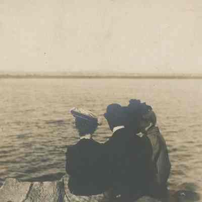 group sitting on shoreline