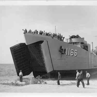LST-1166 next to shore with front hatch open, September 9, 1953