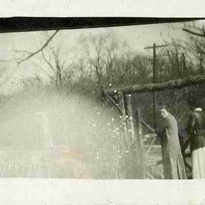 Two women in yard with rustic gate