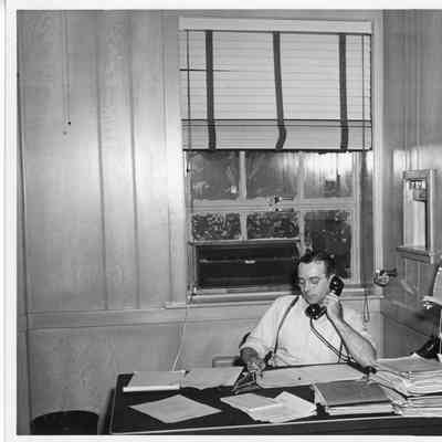 Frank Blinks Behringer at desk with phone