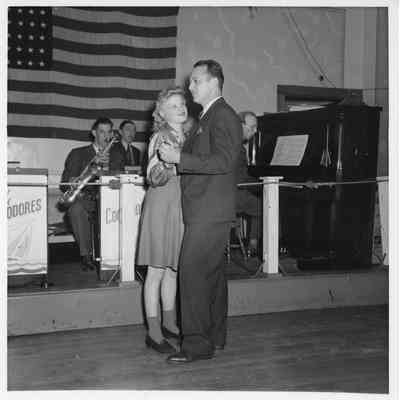 Two people dancing in front of band