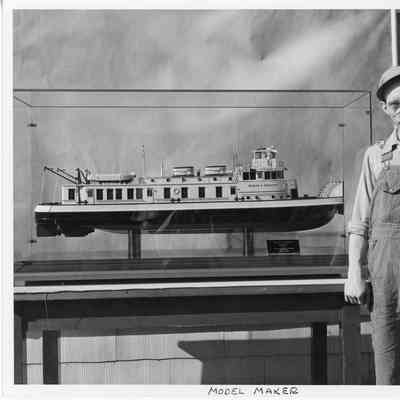 Model maker in front of Anker L. Christy ship model in case